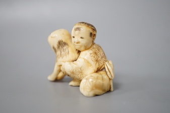 A Japanese ivory netsuke of a boy and puppy, Meiji period, unsigned, 4cm